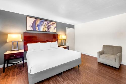 a bedroom with a large bed and a chair at Quality Inn & Suites in Jackson