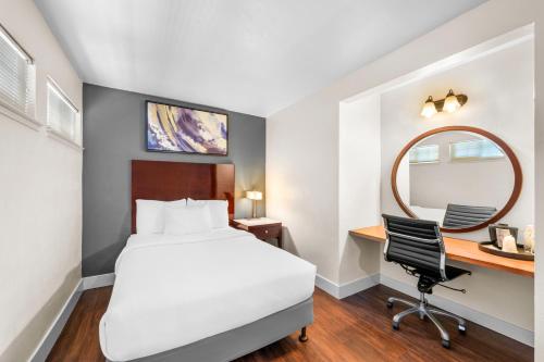 a hotel room with a bed and a desk and a mirror at Quality Inn & Suites in Jackson
