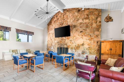 a restaurant with a stone wall with tables and chairs at Quality Inn & Suites in Jackson