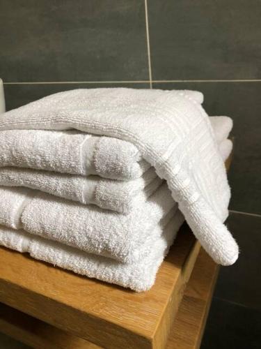 une pile de serviettes blanches assises sur une étagère en bois dans l'établissement Villa Aulan, Luxe et Repos au Château des Gipières, à Montbrun-les-Bains