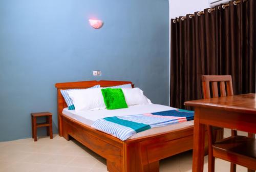 1 dormitorio con 1 cama con mesa y escritorio en JRéside Appart Bleu 50m2 centre-ville, en Cotonou