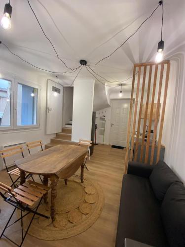 un salon avec une table en bois et un canapé dans l'établissement Jolie maison de village, à Nissan-lez-Enserune