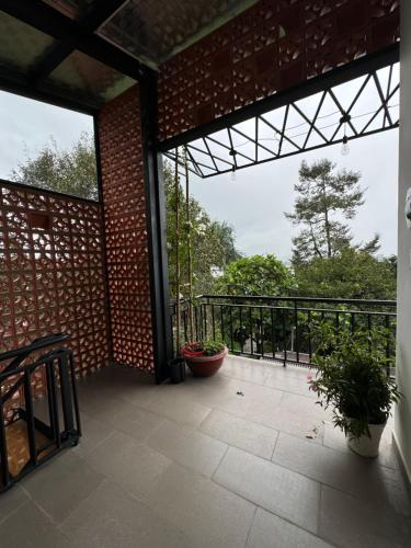 a patio with a brick wall and a balcony at Lanh's Homestay Bảo Lộc in Bao Loc