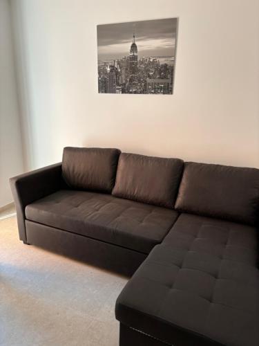 a brown couch in a living room with a picture on the wall at Lazar ONE Aparment in Izola