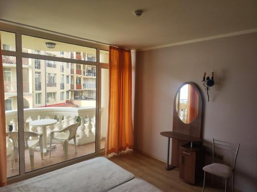 a room with a bed and a window with a table at Elenite Sea View Apartments in Elenite