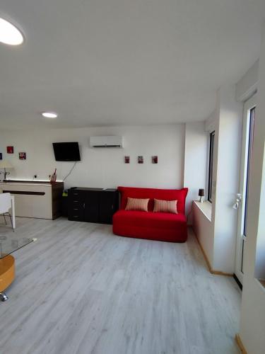 a living room with a red couch and a desk at La Venise du Berry in Argenton-sur-Creuse