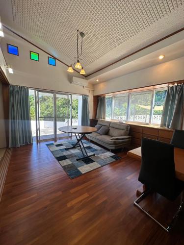 a living room with a table and a couch at Sunrise Vista Nanjyo -SEVEN Hotels and Resort- in Nanjo