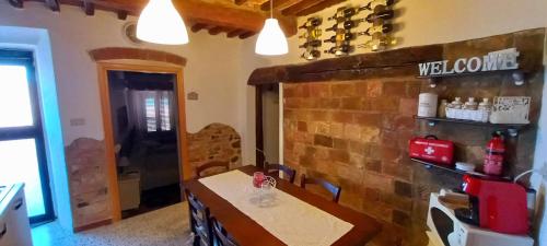 a dining room with a table and a brick wall at Charme & Relax in Centro Storico in Gavorrano