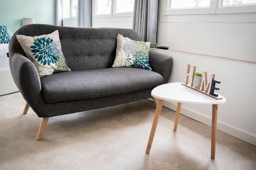 un salon avec une chaise grise et une table blanche dans l'établissement Le Studio - cosy & fonctionnel, clim & piscine, à Roquevaire