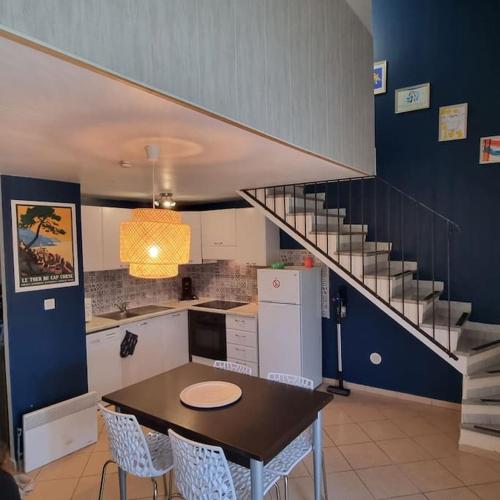 une cuisine avec une table à manger et un escalier dans l'établissement Maison en duplex dans résidence à 400m de la mer, à Belgodère