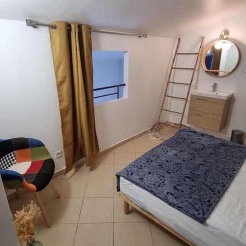 - une chambre avec un lit, une échelle et une chaise dans l'établissement Maison en duplex dans résidence à 400m de la mer, à Belgodère