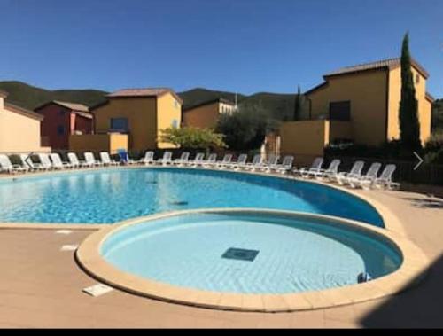 une grande piscine entourée de chaises longues. dans l'établissement Maison en duplex dans résidence à 400m de la mer, à Belgodère