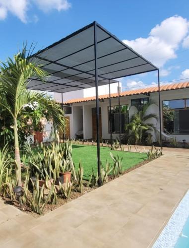 a black canopy over a lawn in front of a house at Posada Casa Bonita in Puerto Maldonado