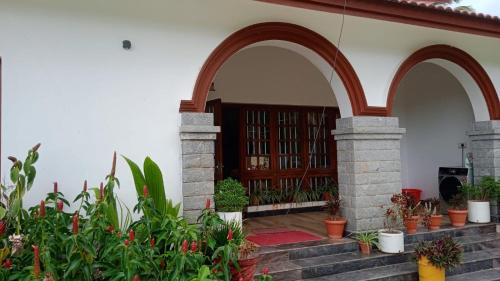 an entry to a house with a door and some plants at NAVARATHNA International resort in Sollebail