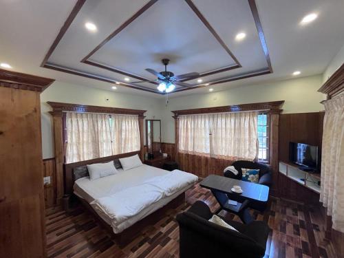 a bedroom with a bed and a couch and a television at NAVARATHNA International resort in Sollebail