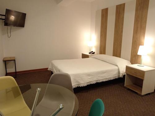a hotel room with a bed and a table and chairs at Hotel Tierrasur in Arequipa