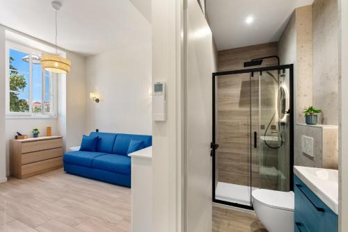 La salle de bains est pourvue d'une douche et d'un canapé bleu. dans l'établissement Residence Massena, à Nice