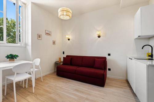 un salon avec un canapé rouge et une table dans l'établissement Residence Massena, à Nice