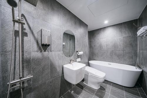 a bathroom with a toilet and a sink and a bath tub at Daegu Exco Lead Hotel in Daegu