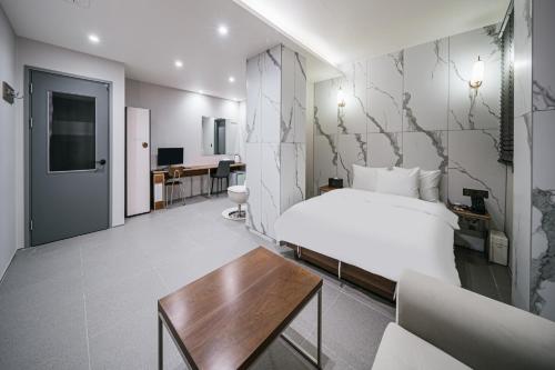 a hotel room with a bed and a table at Daegu Exco Lead Hotel in Daegu