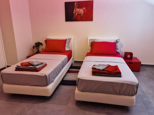 two beds in a room with red pillows on them at Andromeda Sea View Villa in Epáno Eloúnda