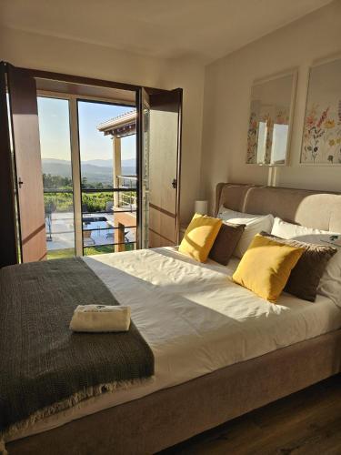 a bedroom with a large bed with yellow pillows at Casa Fonte do Castelo - Casa de Campo in Monção