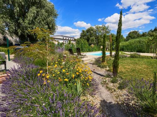 a garden with purple and yellow flowers and a pool at Vinařský dům Kovárna in Březí
