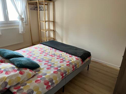 un lit avec des oreillers dessus dans une chambre dans l'établissement Normandy trip 5 min à pied de la plage, à Courseulles-sur-Mer