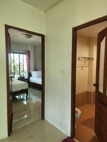 a room with a door leading to a bedroom with a bed at Loy Manee House in Phra Nakhon Si Ayutthaya