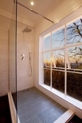 a bathroom with a shower with a large window at The Great Gatsby Houghton in Johannesburg