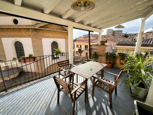 un patio con tavolo e sedie su un balcone di Santa Lucia a Caltanissetta