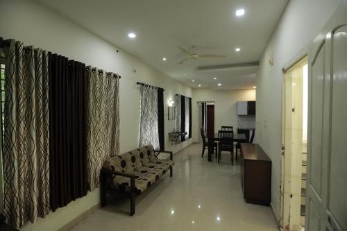 a living room with a couch and a dining room at Nest in Ernakulam