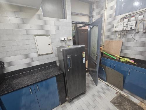 a kitchen with a sink and blue cabinets in a room at Deer Park Home Stay in New Delhi