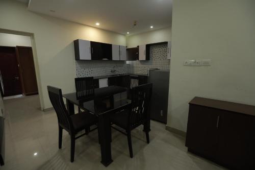 a kitchen with a table and chairs in a room at Nest in Ernakulam