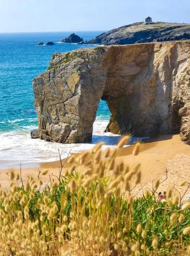 une arche dans les rochers sur une plage près de l'océan dans l'établissement Villa Bailey, à Quiberon