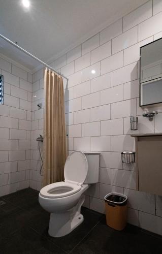 a bathroom with a toilet and a shower at Malinawon Resort 馬莉吶灣度假中心 in Panglao Island