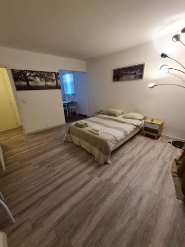 une chambre avec un grand lit et un parquet dans l'établissement Logement entier tout confort, à Saint-Cyr-lʼÉcole