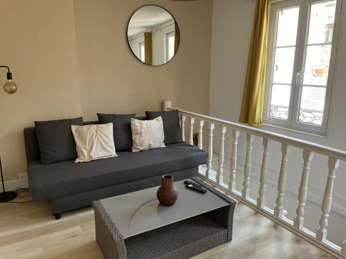 un salon avec un canapé et un miroir dans l'établissement Charmant Duplex Intra-Muros, à Avignon