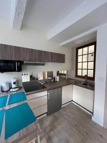 une cuisine avec des placards blancs et un comptoir bleu dans l'établissement Charmant Duplex Intra-Muros, à Avignon