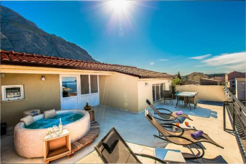 a backyard with a hot tub on a patio at Penthouse with HotTub and Duplex in Makarska