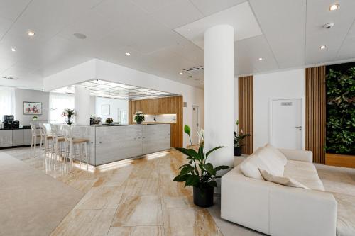 a living room with a white couch and a kitchen at Hotel Silenzio in Prague