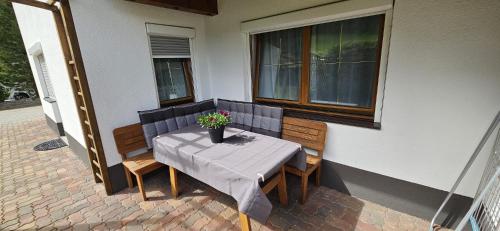 a table with a vase of flowers on a patio at Appartement Mair in Sankt Leonhard im Pitztal