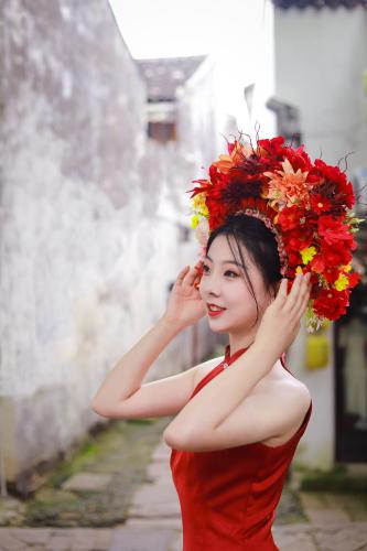 a woman in a red dress with a wreath on her head at Tongli Slowlife River View Inn in Suzhou