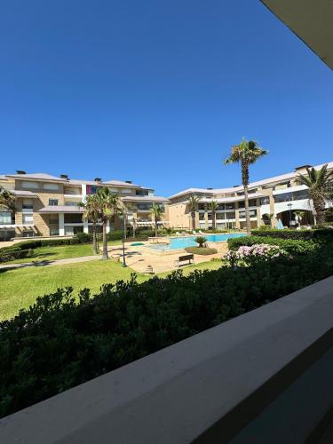 a view of a resort with a pool and palm trees at Prestigia PDN in Sidi Bouqnadel