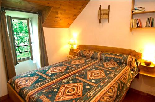 - une chambre avec un lit doté d'un couvre-lit coloré dans l'établissement Gîte Le Petit Gîte 2/4 personnes à Valbelle, à Florac Trois Riviere