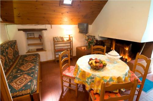 une salle à manger avec une table avec un bol de fruits dessus dans l'établissement Gîte Le Petit Gîte 2/4 personnes à Valbelle, à Florac Trois Riviere