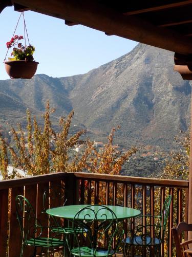 a table and chairs on a balcony with a mountain at Alagonia Country Homes in Alagonía