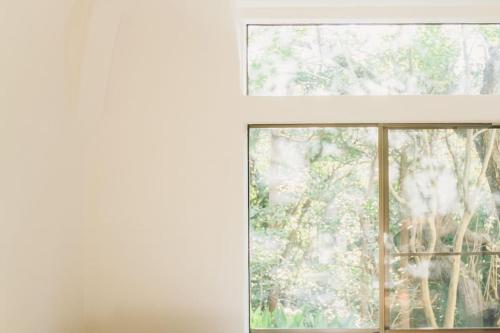 an open window with a view of a tree at 伊豆大島の一棟貸切Retreat&StayBHOAG広いお庭でBBQ焚火okお子様歓迎8名定員 in Oshima