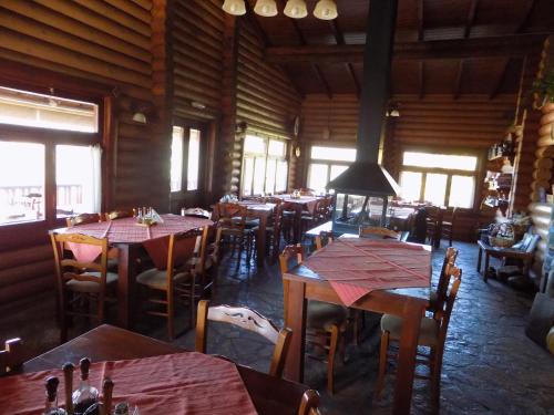a dining room with tables and chairs and windows at Alagonia Country Homes in Alagonía