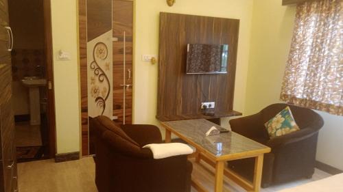 a living room with two chairs and a table at NAVARATHNA International resort in Sollebail